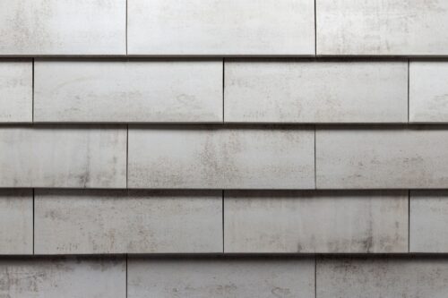 Exterior wall made of light gray concrete blocks with faint weathering lines.